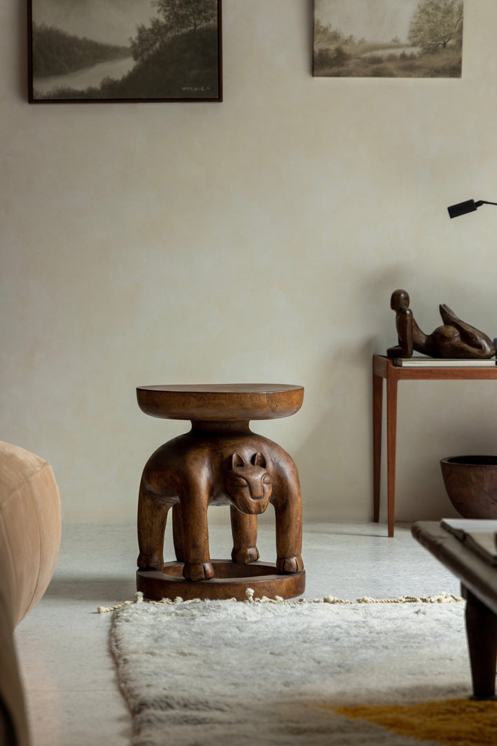 Handcrafted wooden Tribal Sculptural End Table in stylish living room, adding unique decor.