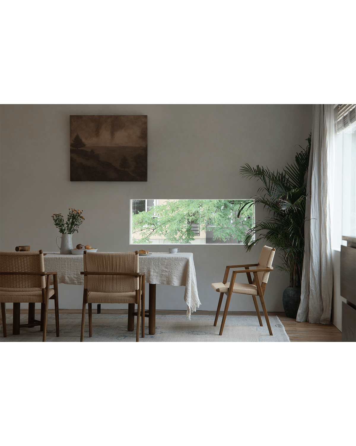 Louisa Chair in dining room setting. Teak frame and woven seat chairs. Mid-Century Modern design.