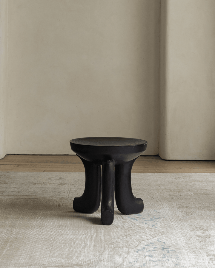 Quincy stool with unique curved legs in minimalist room setting