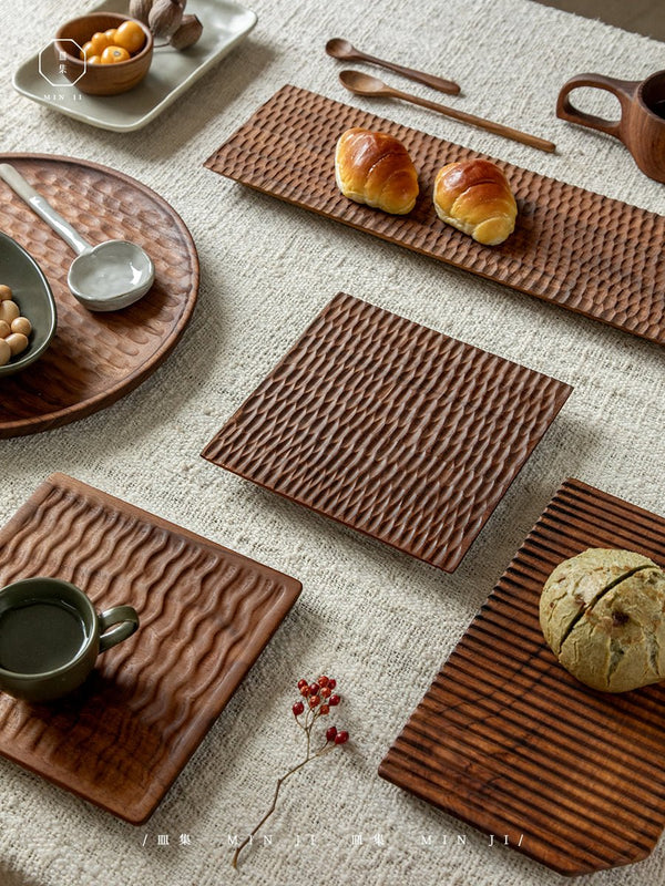 Textured wooden serving trays with croissants and snacks on a linen tablecloth