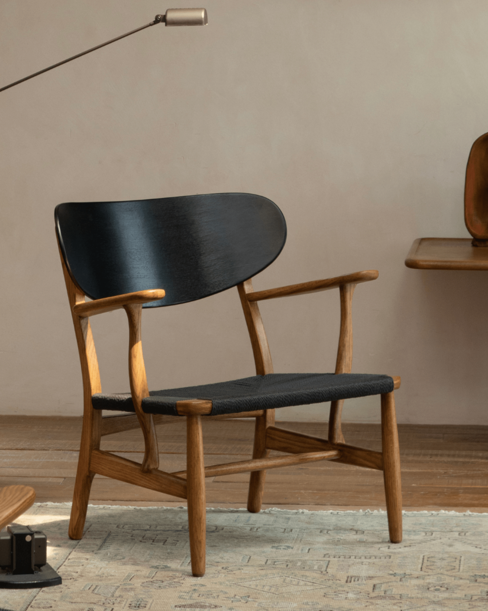 CH22 Lounge Chair with black backrest and woven cord seat, showcasing Scandinavian design in natural oak.