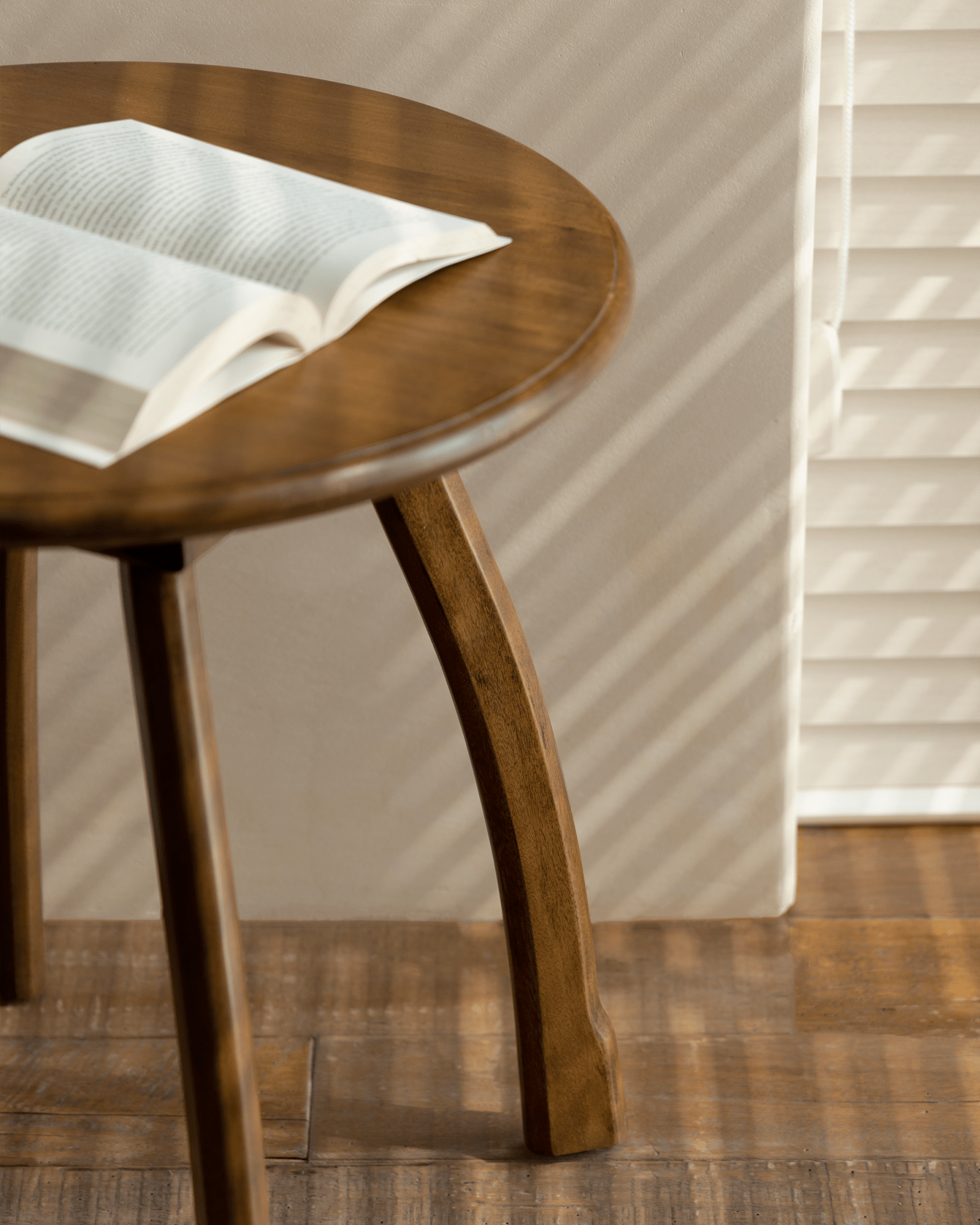 Ele Round Side Table with open book. Vintage Phoebe wood table with octopus legs in a cozy setting
