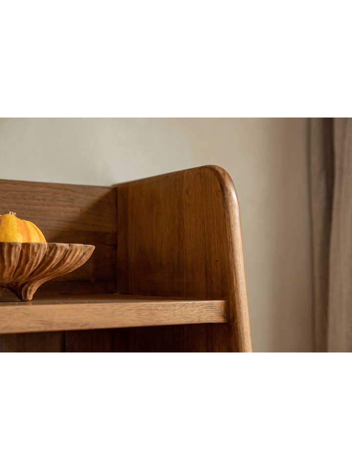 Close-up of Lidi Display Cabinet corner with wooden bowl and decorative fruit.