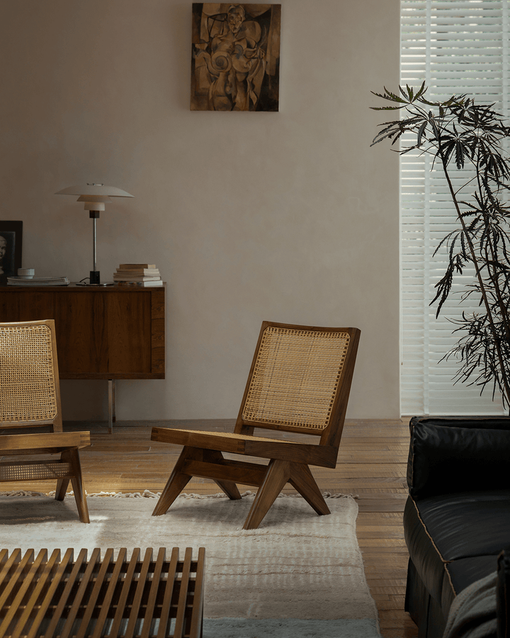Chandigarh Armless Easy Chair with woven rattan backrest in modern living room.