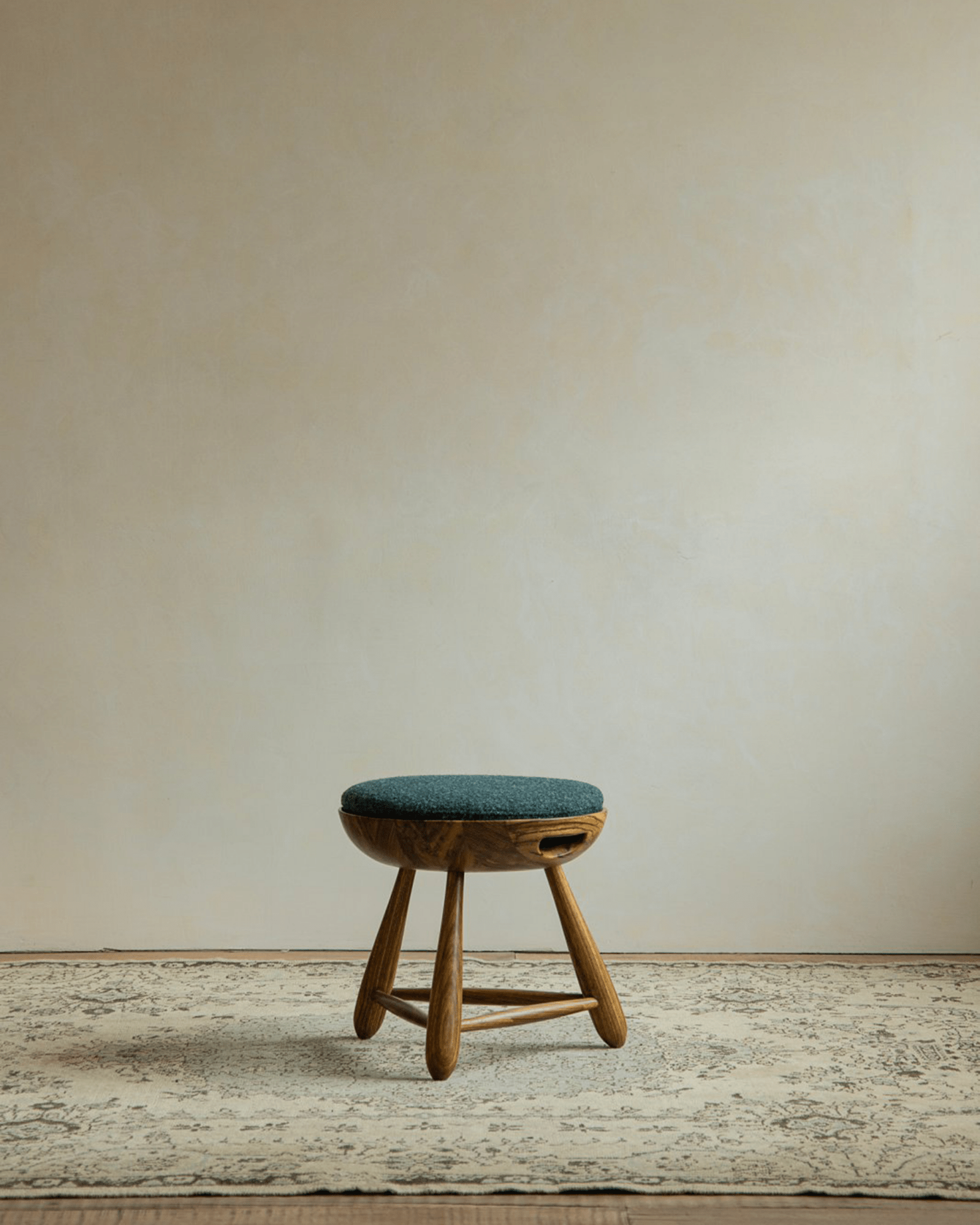 Zebrawood Mocho Stool with teal cushion, organic design, and tripod legs. Modern stool.