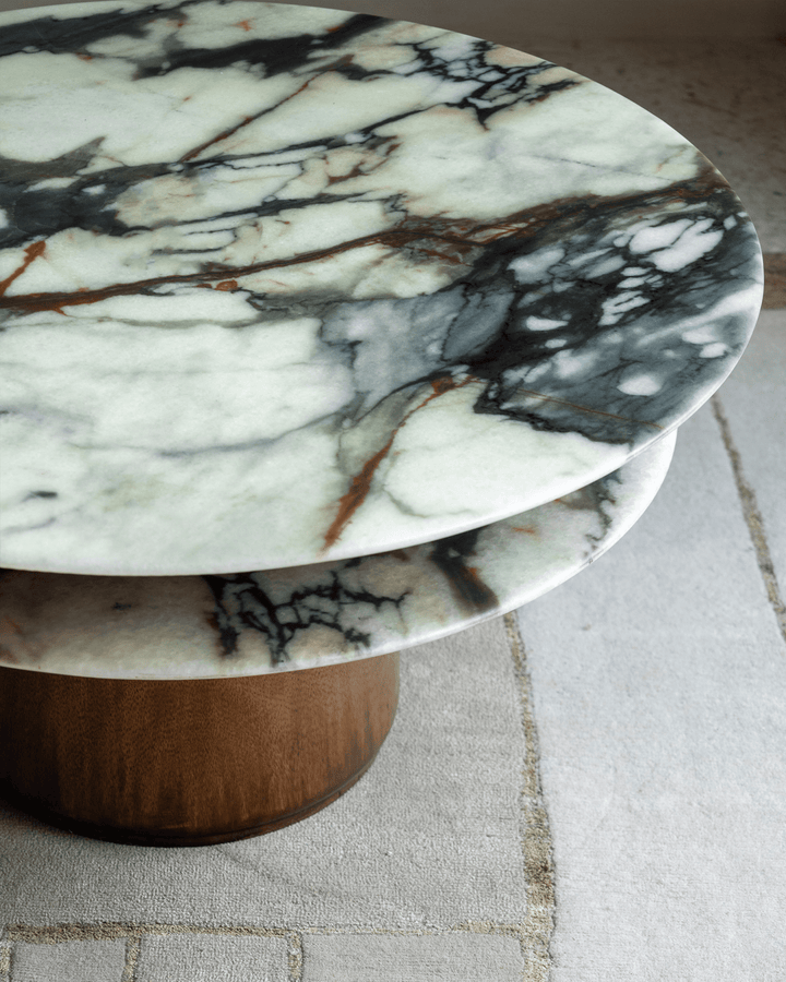 Elegant round marble side table with a wooden base, showcasing intricate veining.