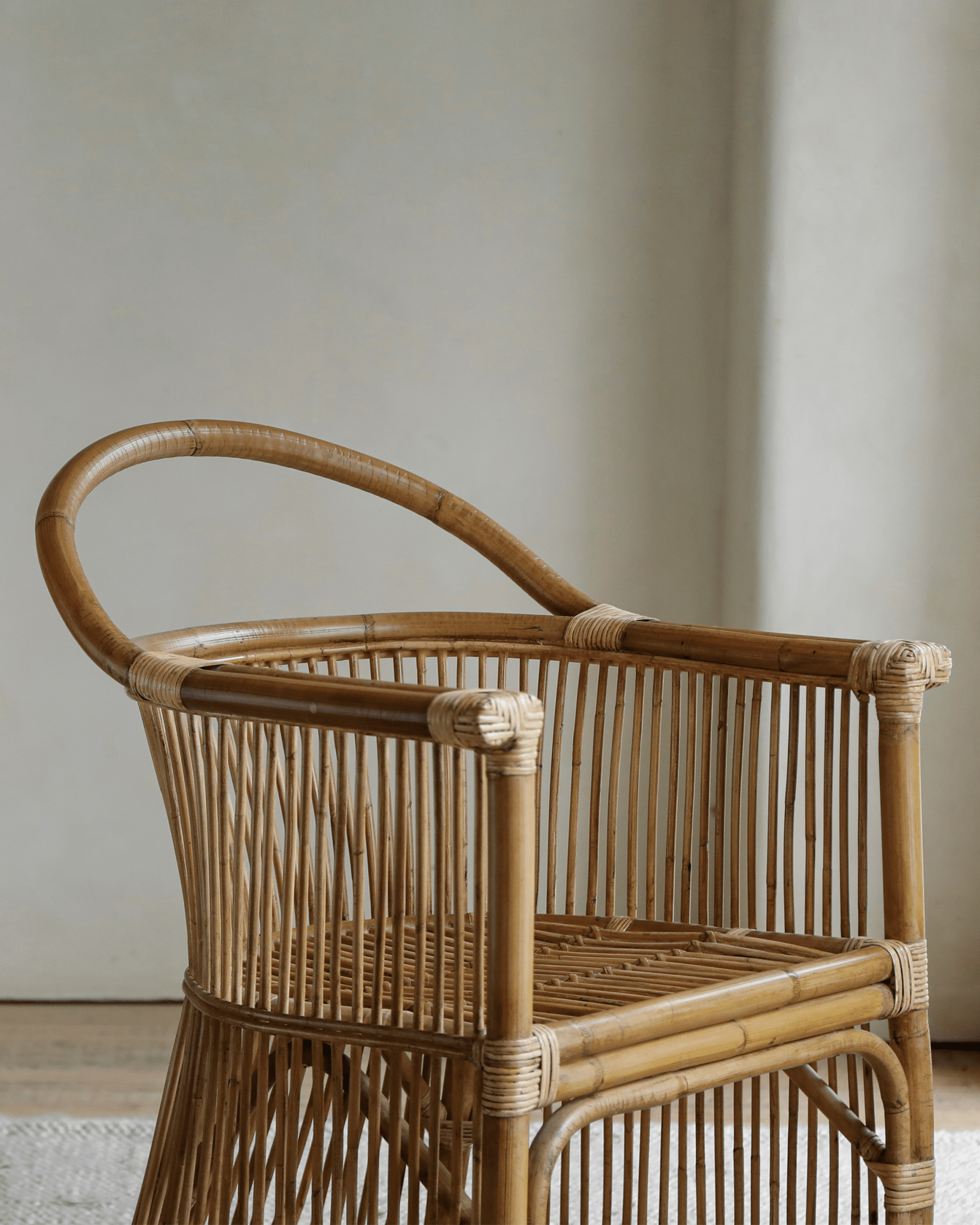 Cape Chair - Natural rattan chair with a unique hanging backrest design, a spacious seating area, and elegant lines