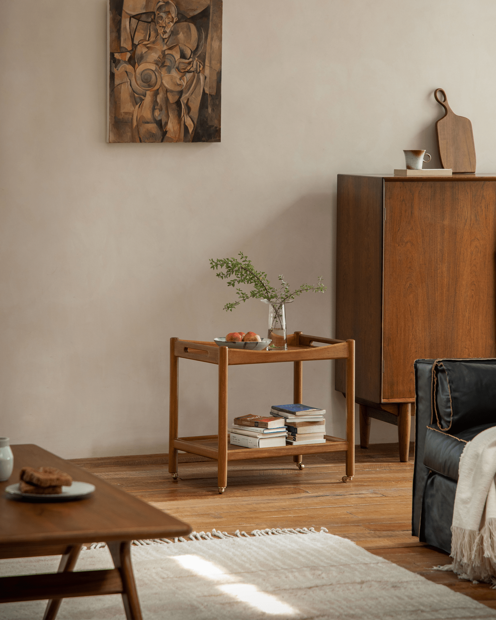 Brooklyn Bar Cart styled in living room with wooden bar cart, brass casters, and wooden cabinet.
