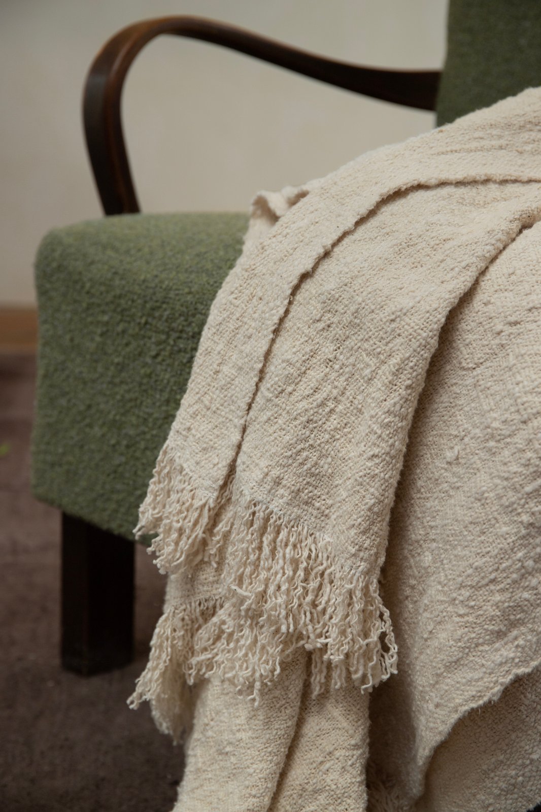 Cream cotton blanket with fringe on green armchair; Cotton blanket for home decor