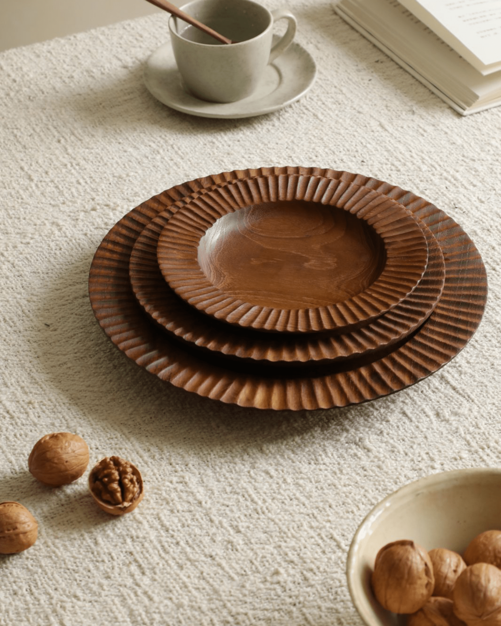 Handmade teak wood Lace Plates set on table with walnuts. Elegant Indonesian plates for dining.