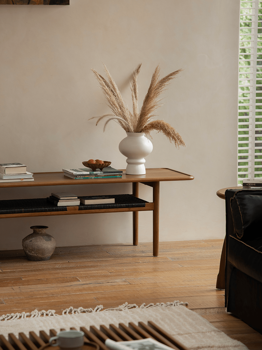 Hans Accent Table in a modern living room, wooden coffee table with woven shelf, minimalist design.