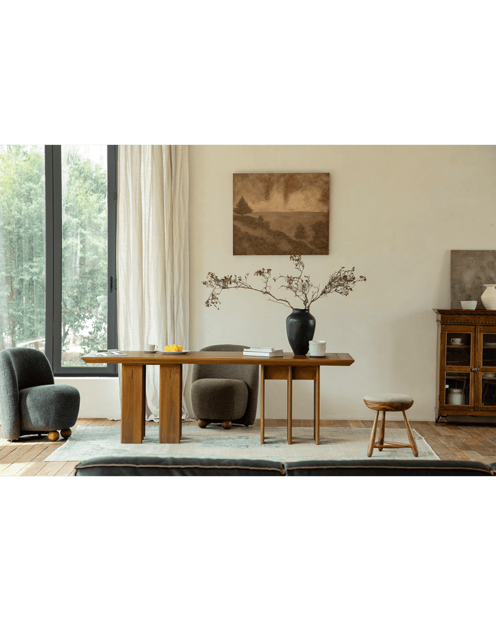 Modern teak dining table with decorative vase, two chairs, and natural light in a cozy setting.