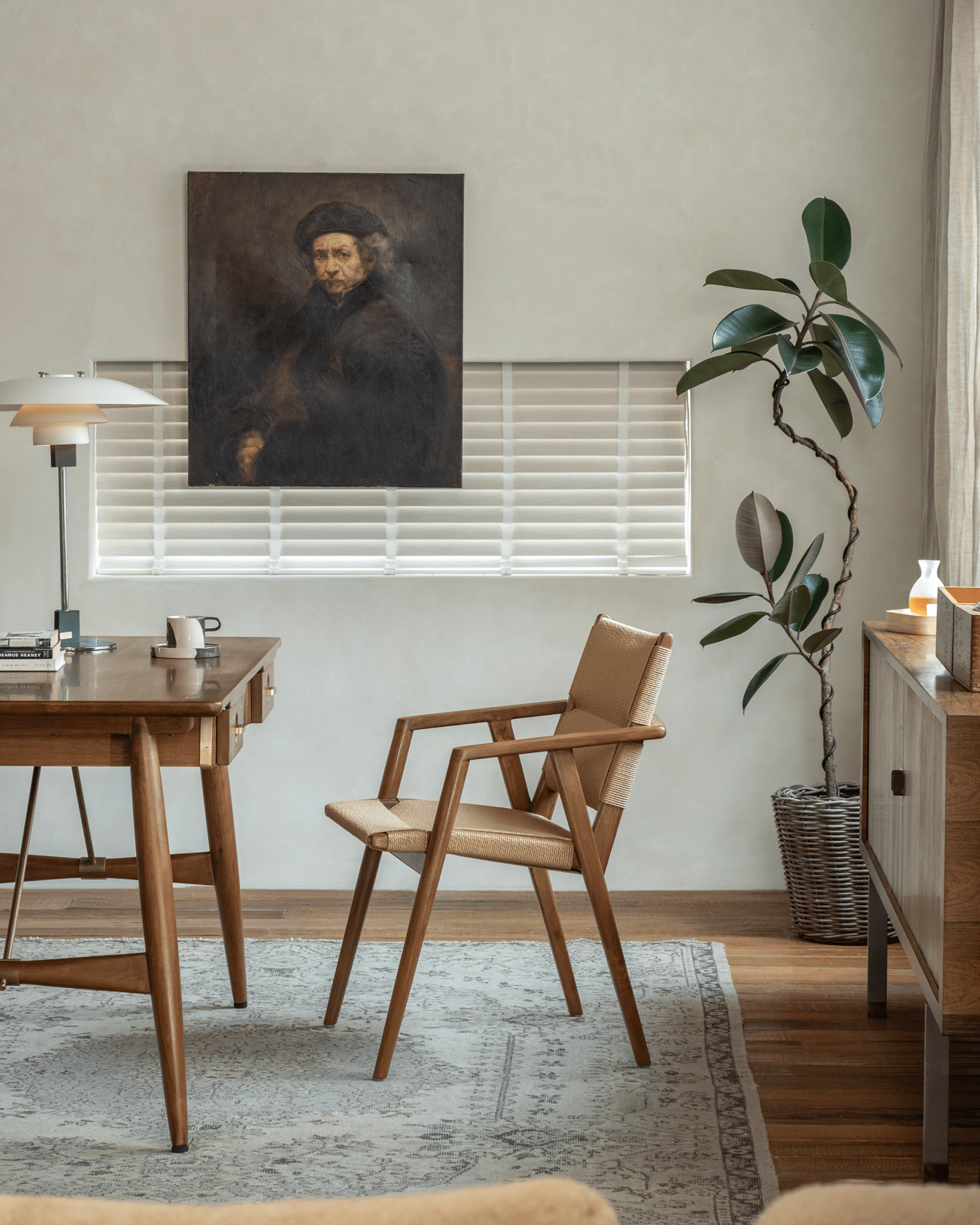 Luisa Chair in a study setting with teak frame and woven seat, Mid-Century Modern design, wooden desk