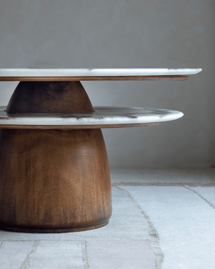 Round side table with marble top and wooden base, showcasing elegant design.