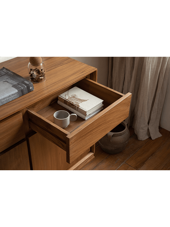 Open drawer of NO.44 teak sideboard with books and coffee mug