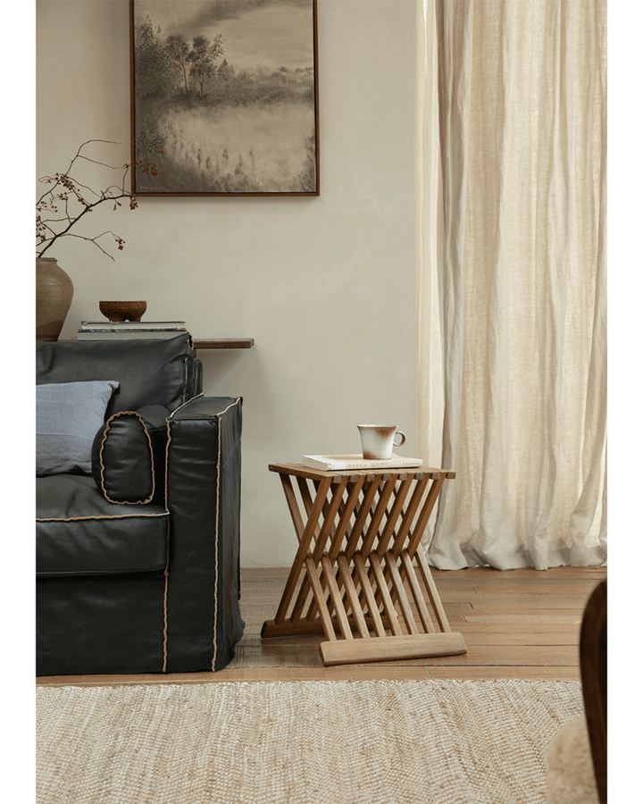 Stylish folding coffee table next to a cozy sofa in a bright living space.