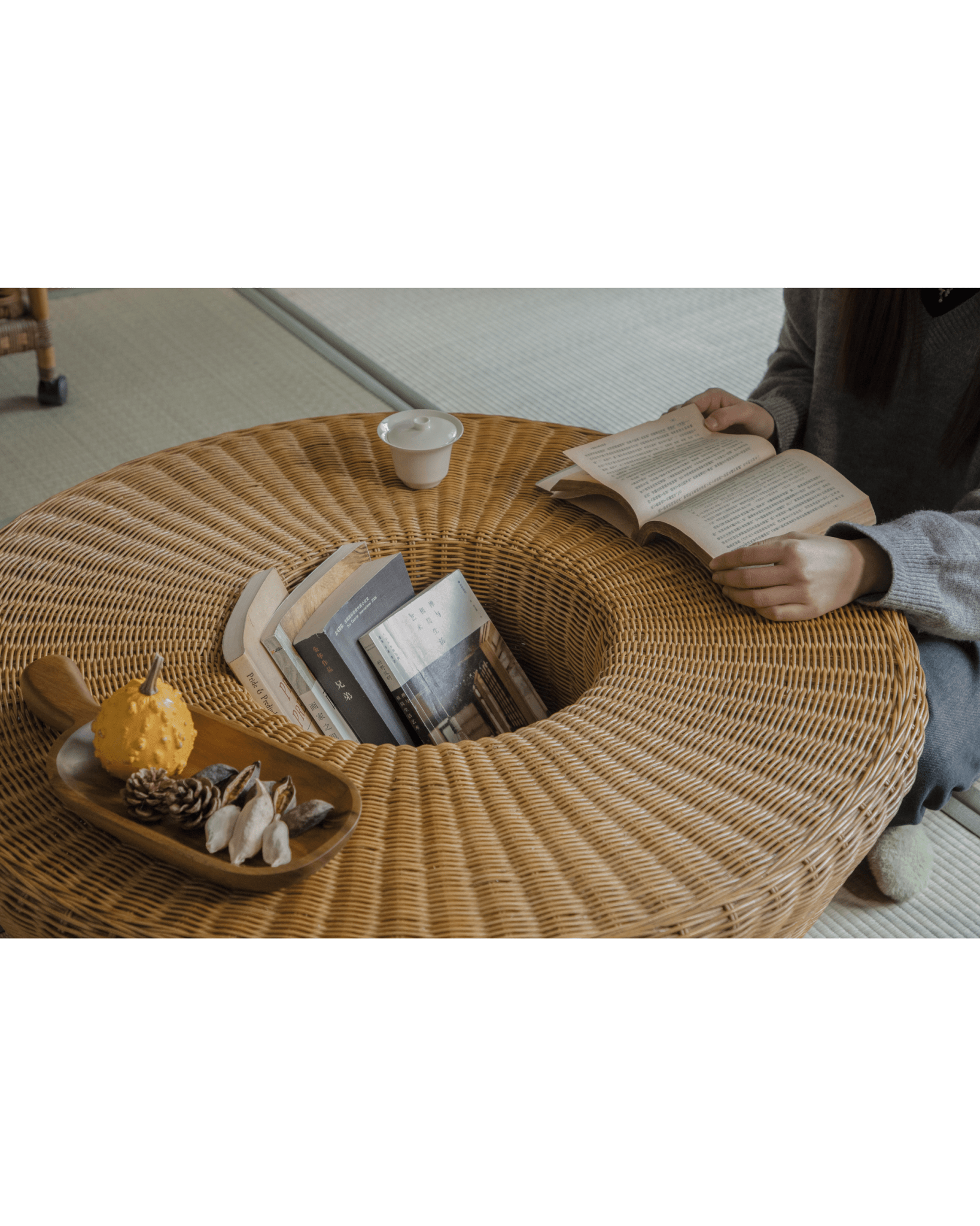 ZM Home Nest Coffee Table with woven rattan design, person reading books, stylish centerpiece, sunken storage