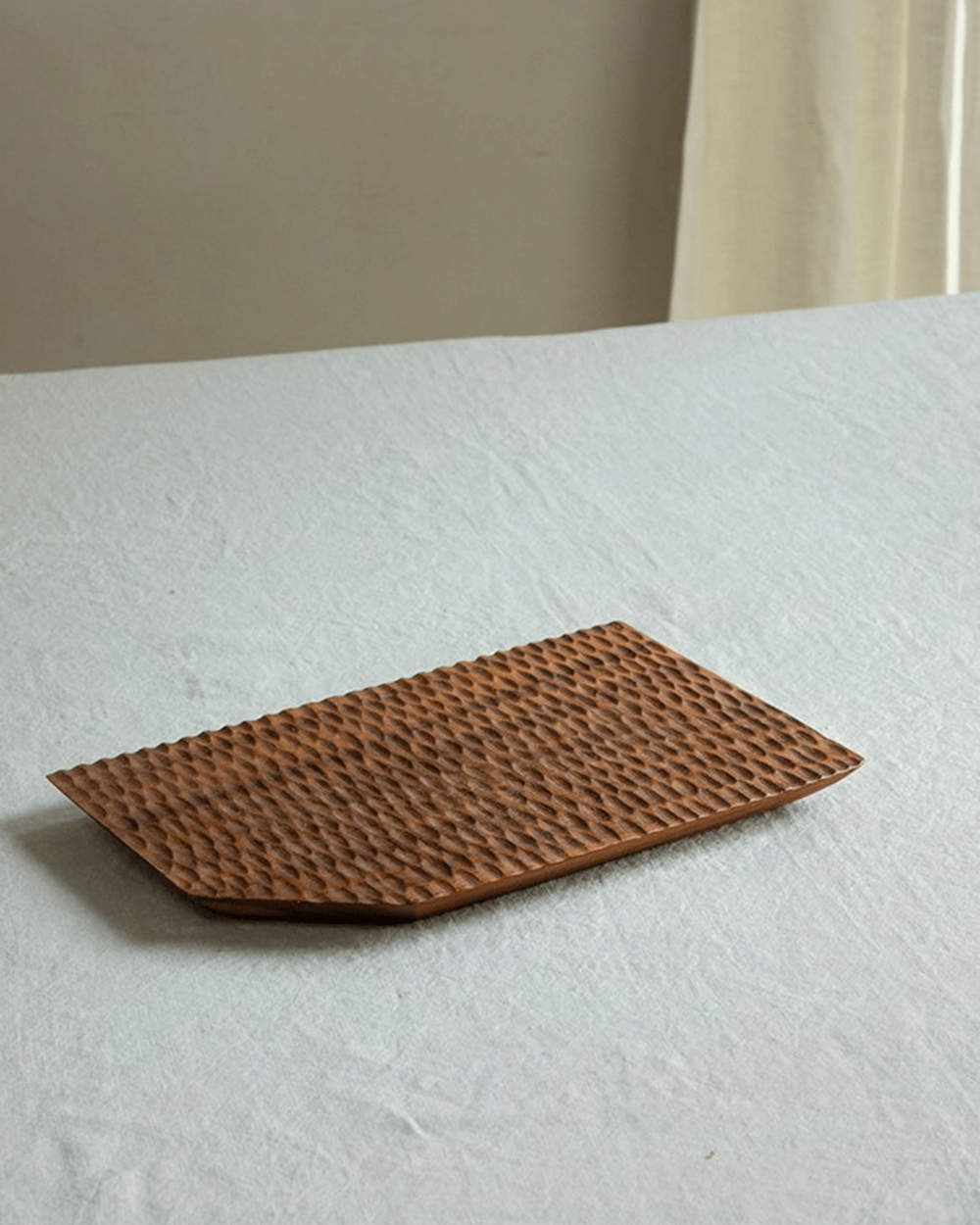 Handcrafted teak wood serving tray with textured surface and artisan design, perfect for serving and display.