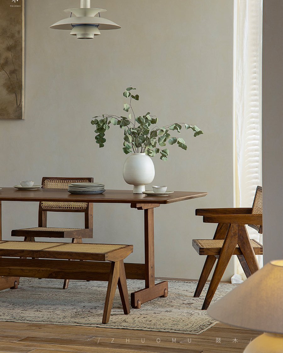 Hoof Dining Table in a cozy dining setting with I-shaped base, solid wood table, ZHUOMU brand, woven chairs and bench.