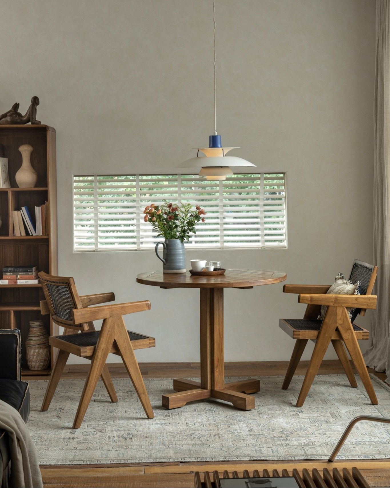 Ruby Teak Round Table in dining setting with chairs, featuring solid wood craftsmanship and column legs
