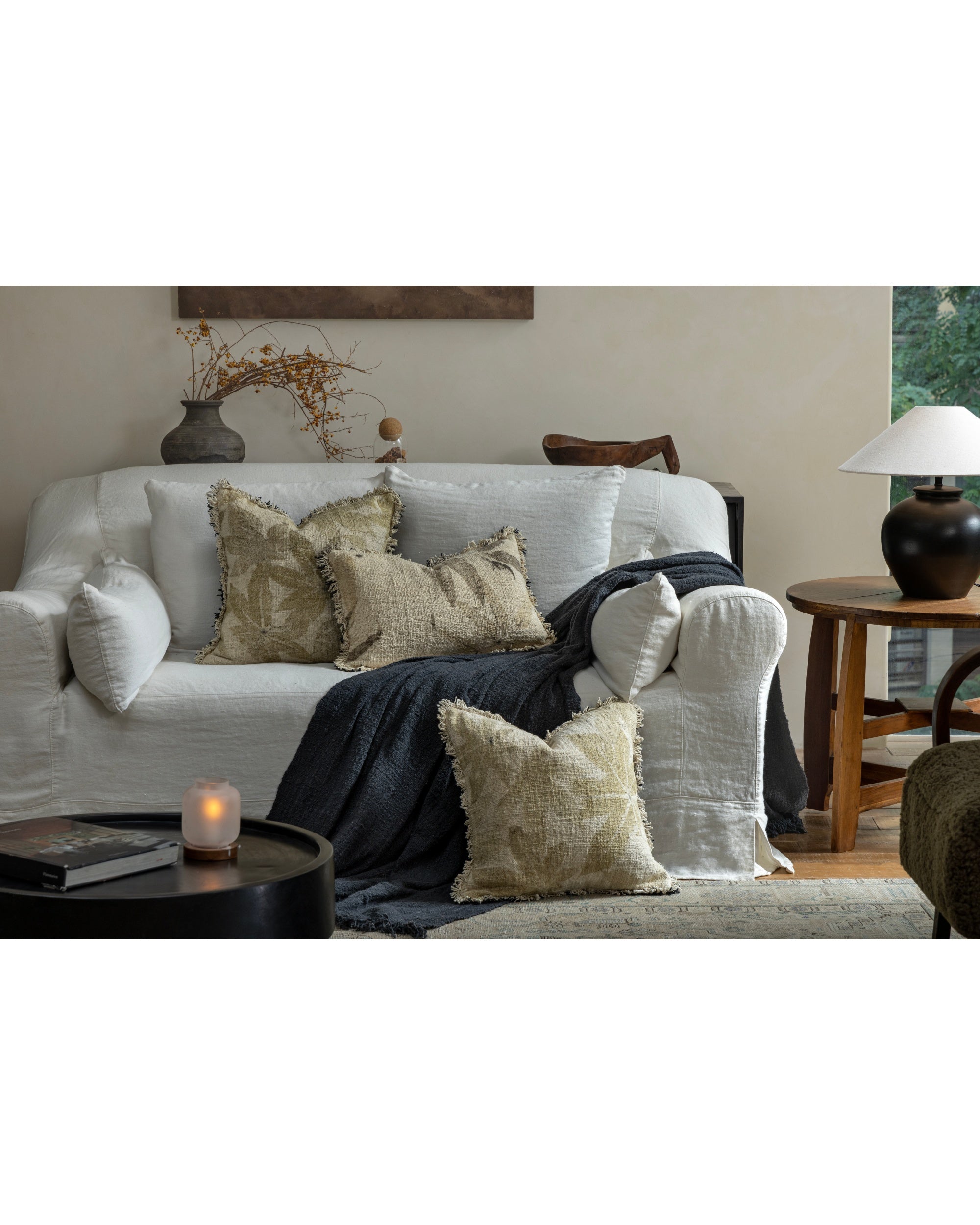 Verda Pillow: Hand-crocheted cotton with textured botanical print on a sofa.