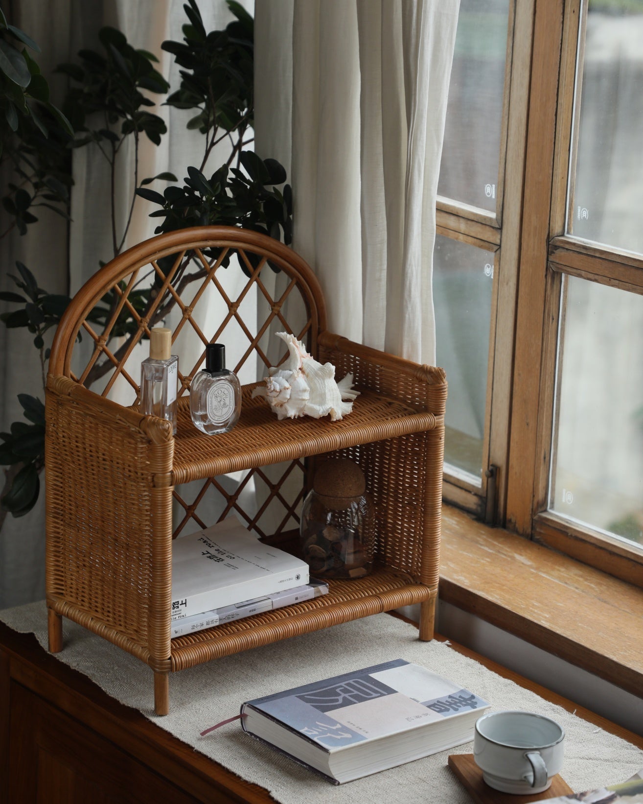Solana Stand: Natural rattan shelf with arched back, diamond weave, and two open storage shelves.