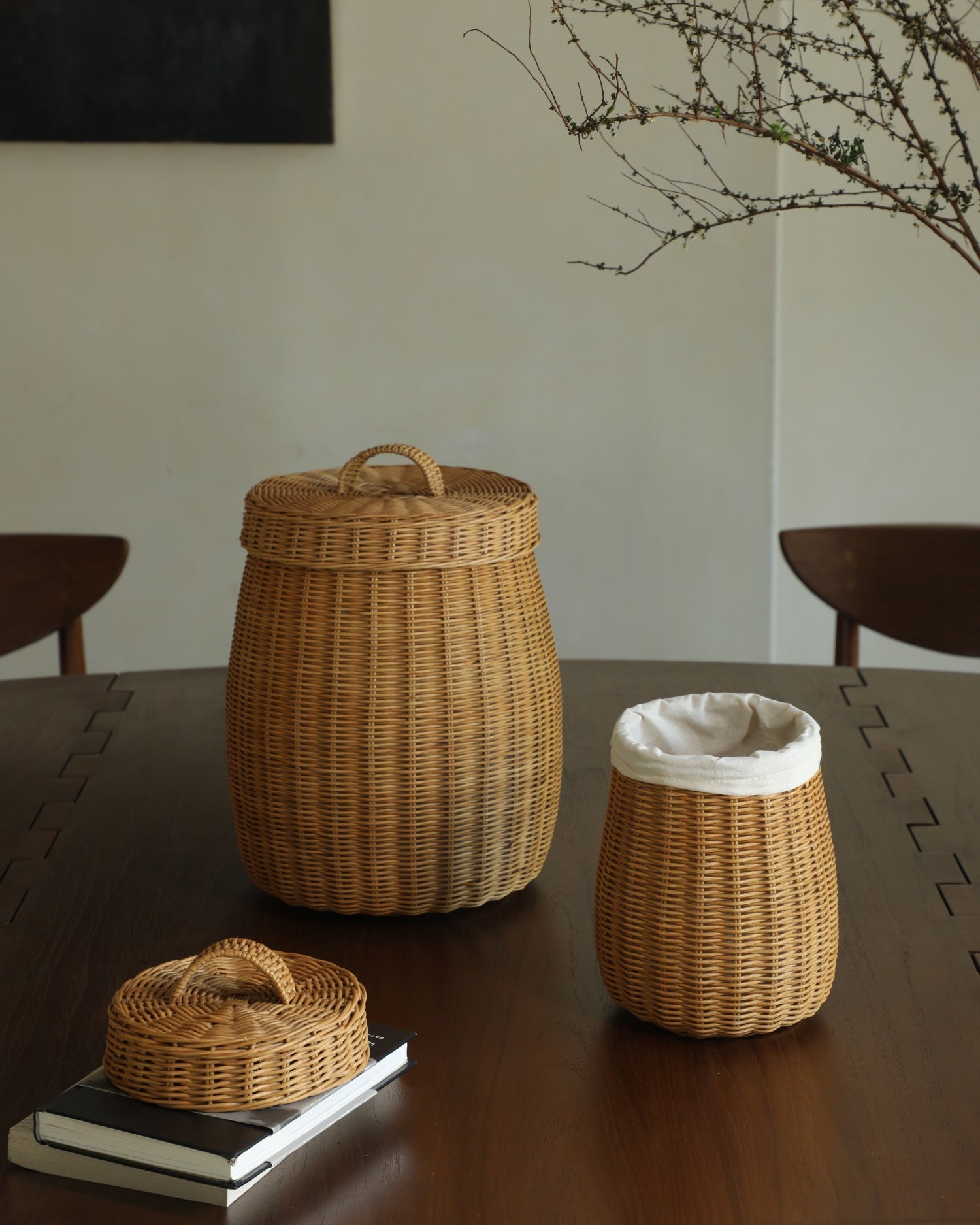 Elodie Round Storage Basket (large) in woven rattan with lid, beside small lined basket.