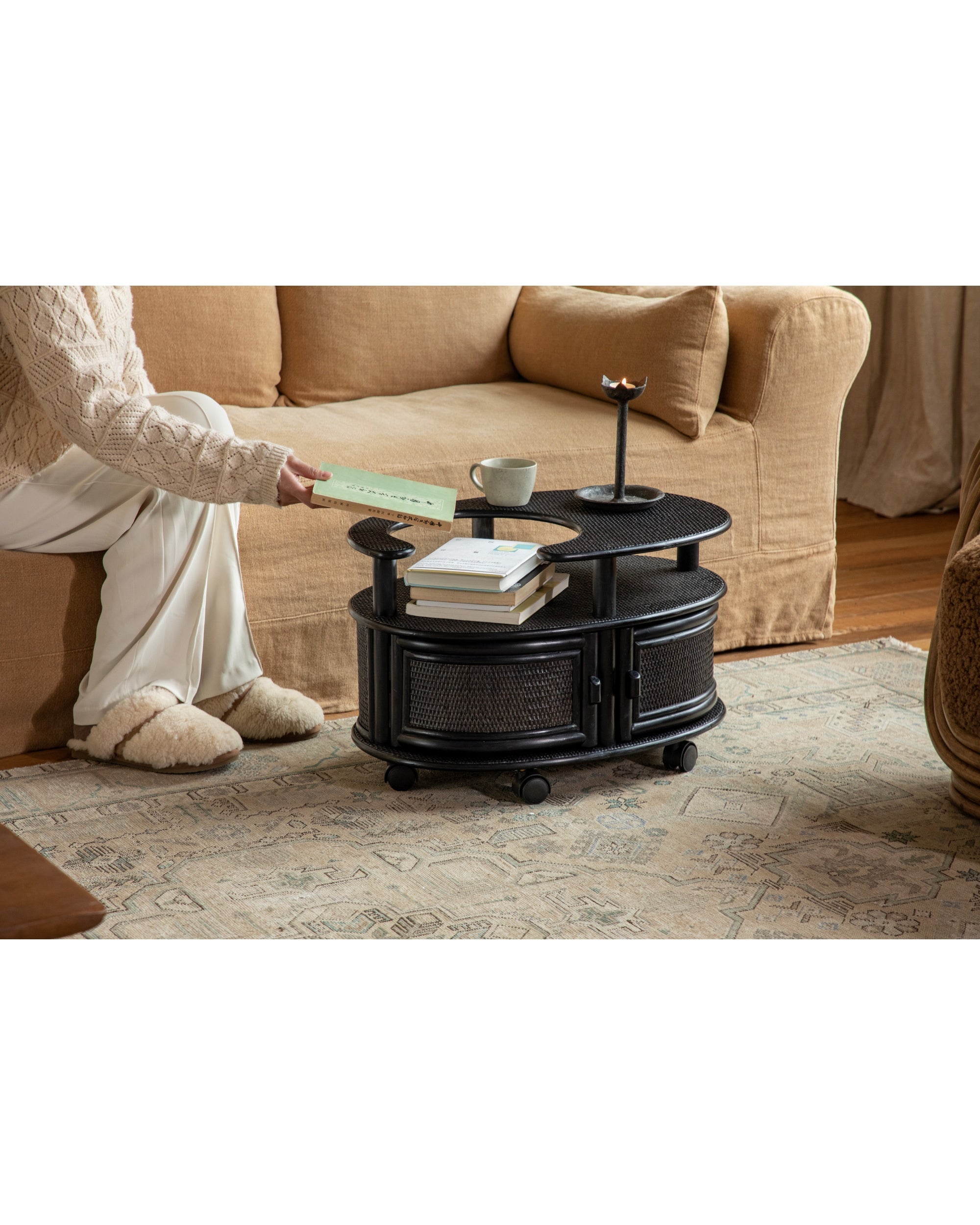 Black Noa Rattan Wheeled Table with double-layer top and cabinet storage.