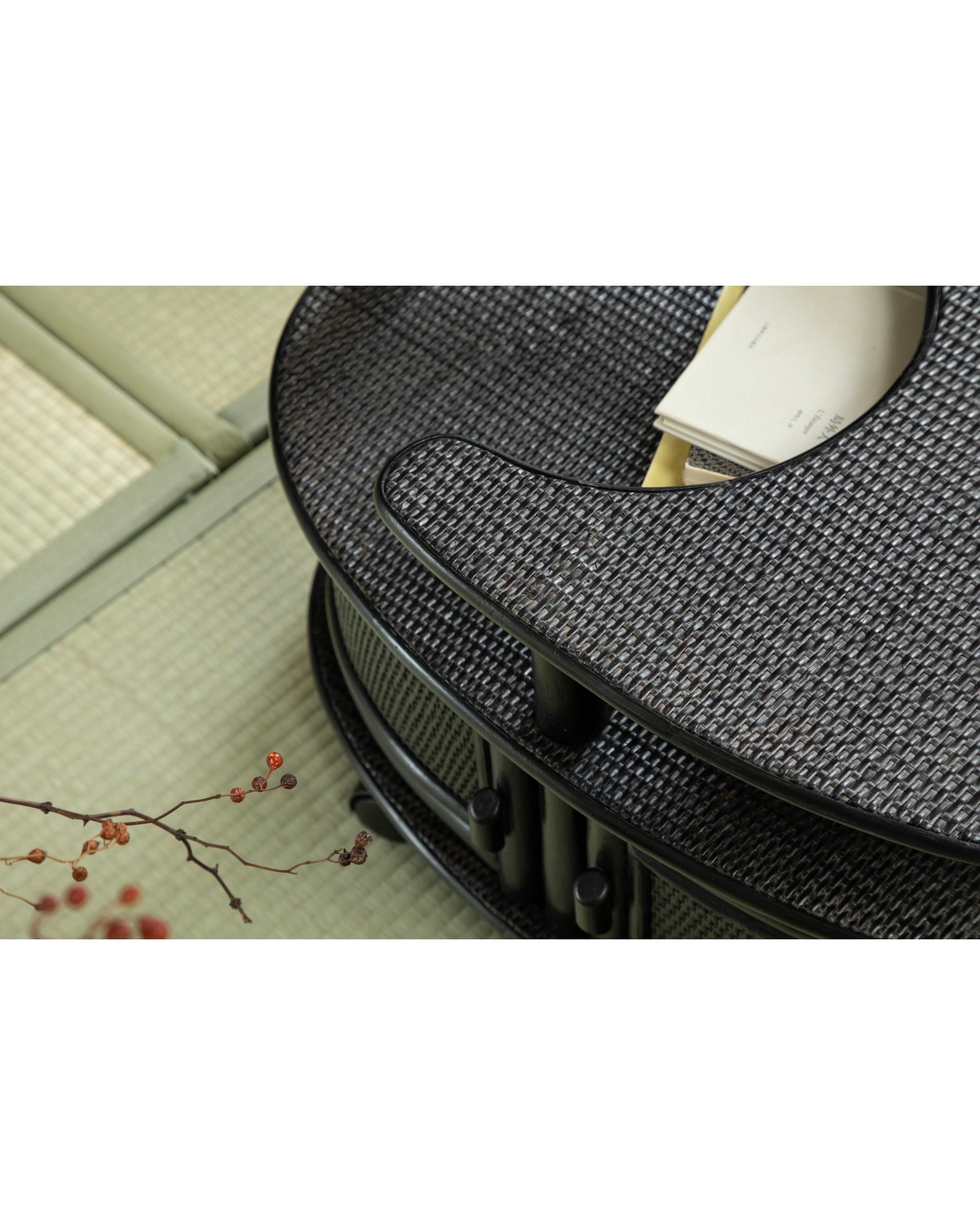Noa Rattan Wheeled Table: dark woven rattan with natural branch detail.