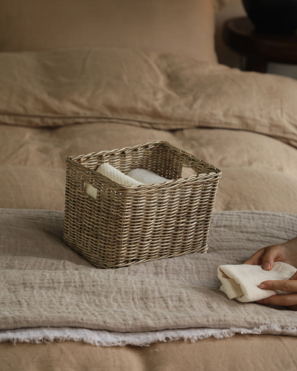 Handwoven rectangular Loma storage basket on a bed, natural fiber weave