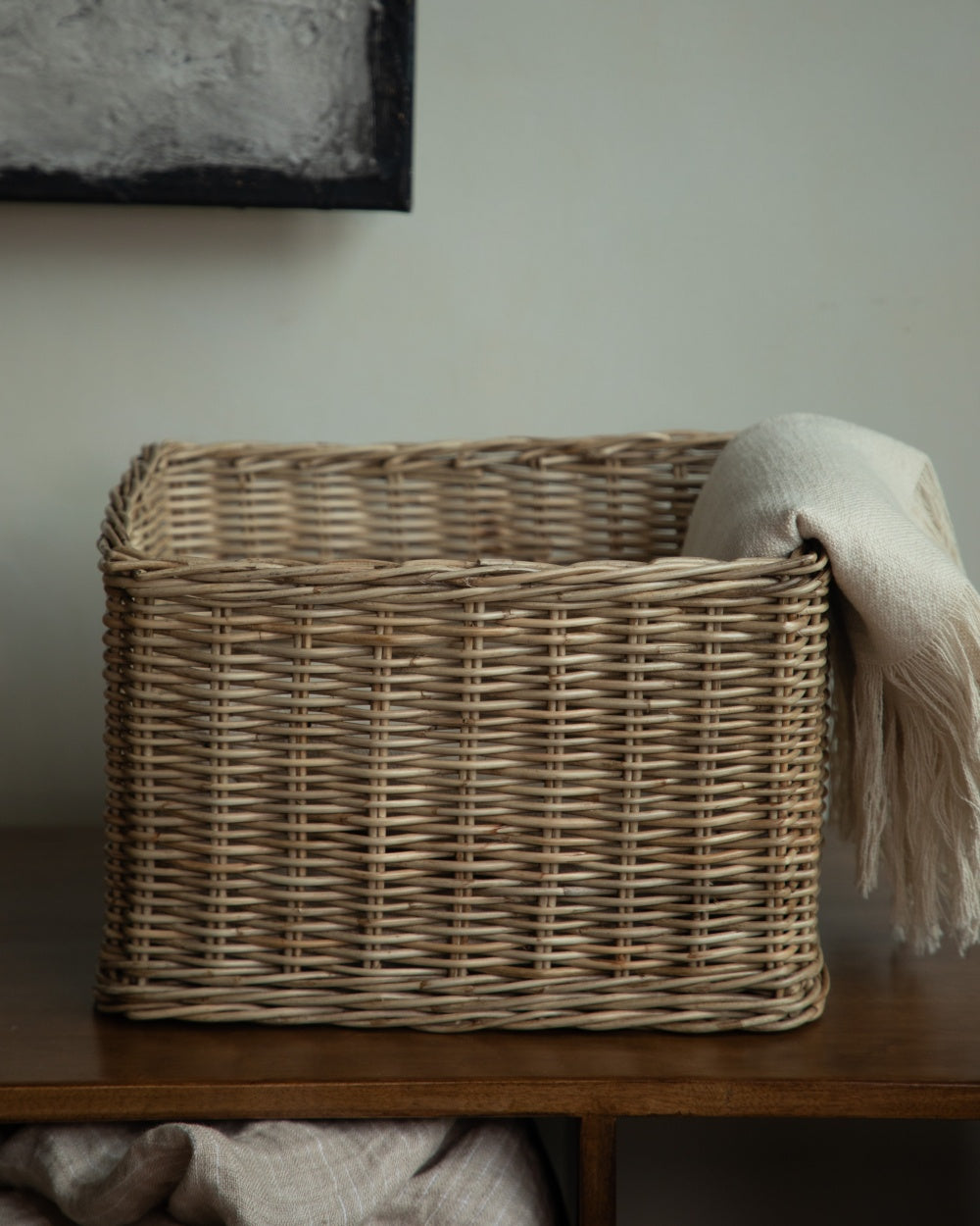 Natural woven storage basket with thick rectangular weave on wooden shelf
