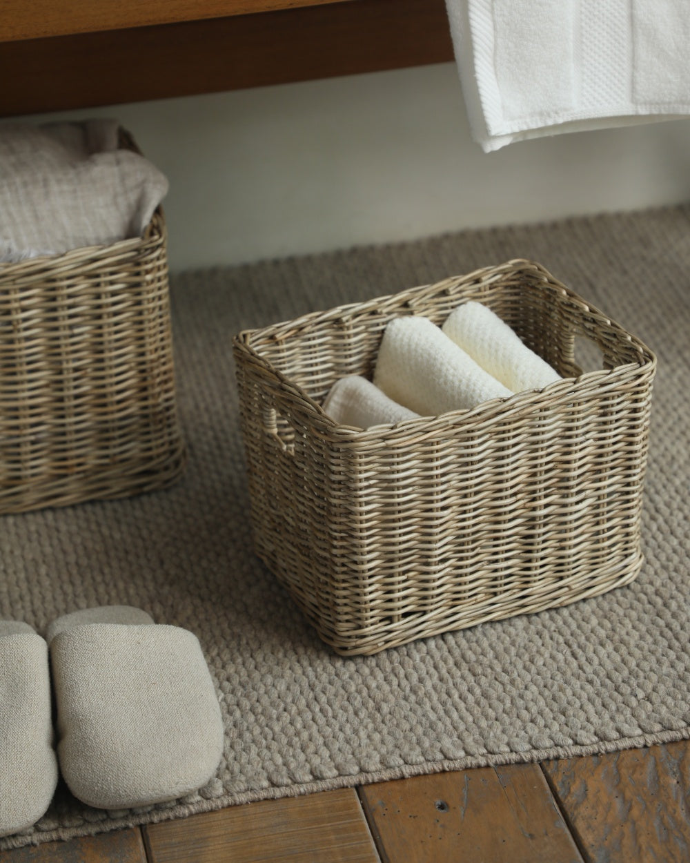 Rectangular natural fiber Loma storage basket with thick weave, holding folded towels