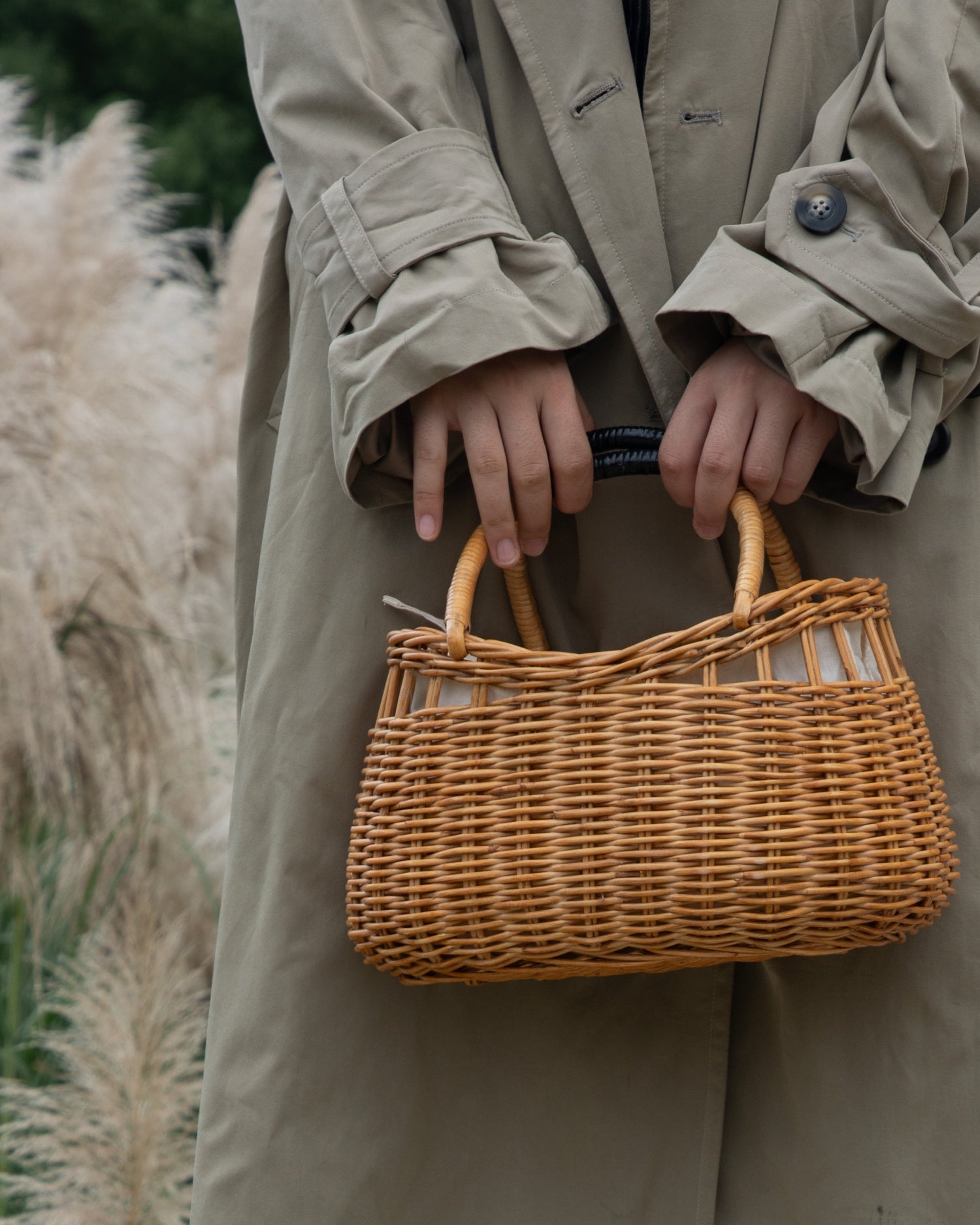 Woven rattan Ivy Hand Bag with curved wicker handles against a soft, natural background.