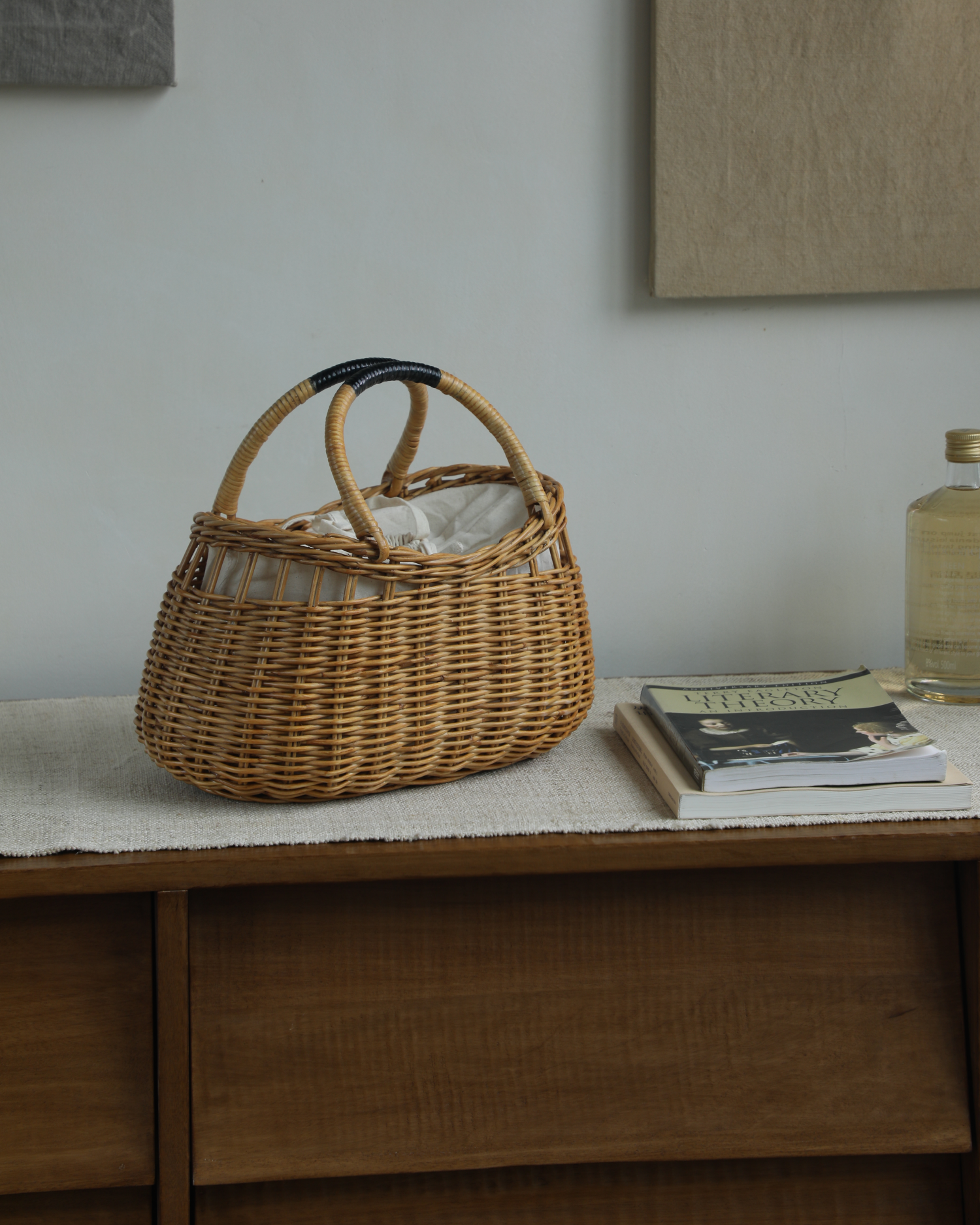 Woven rattan Ivy Hand Bag with curved handles and white fabric lining.