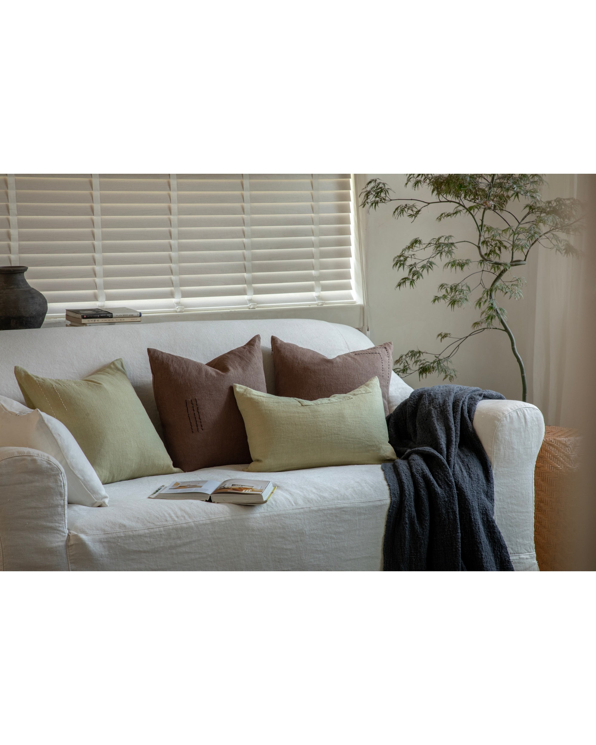 Linora embroidered yarn-dyed linen pillow in sage green and brown with handcrafted stitching.