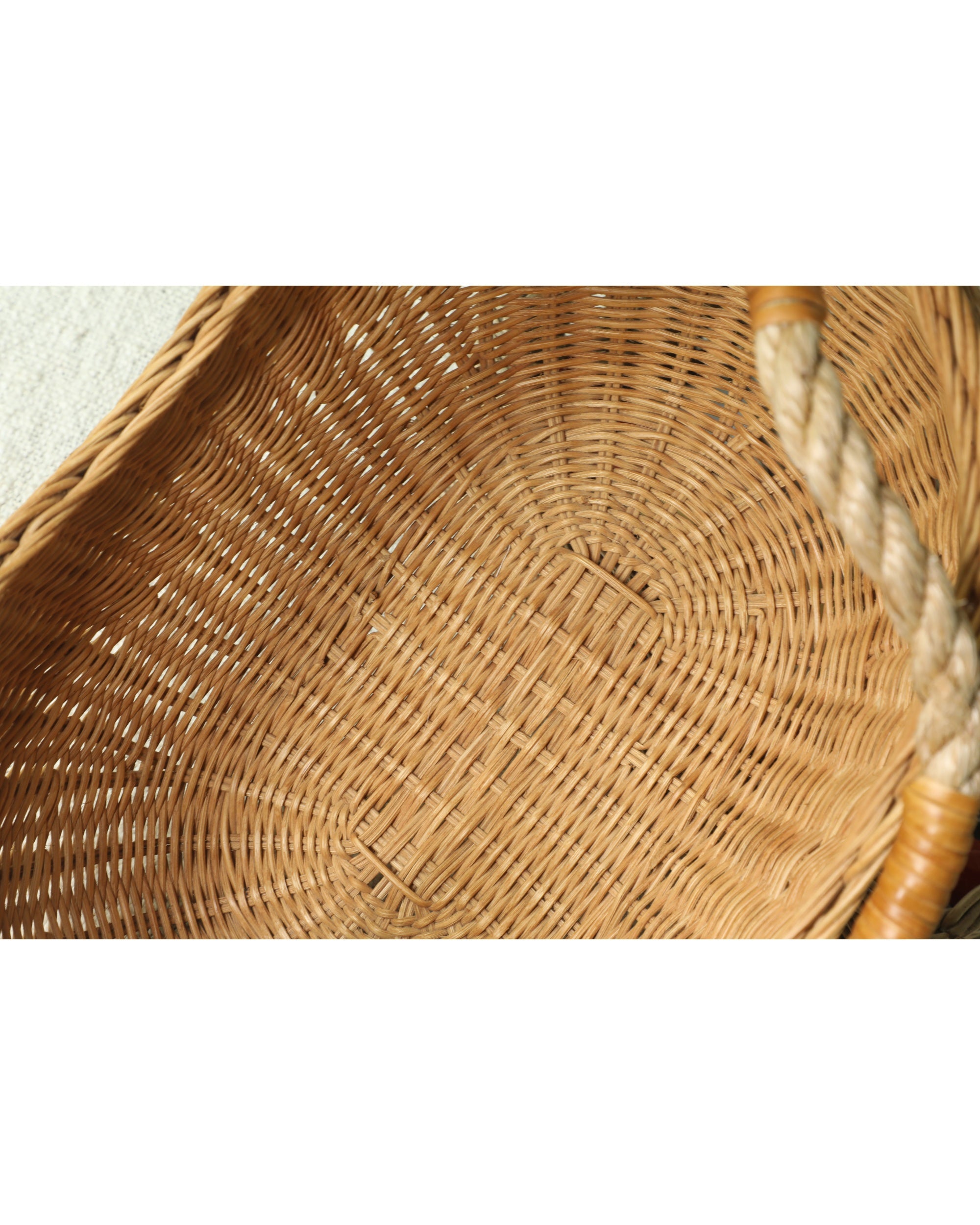 Handwoven wicker storage basket interior with sturdy woven base and rope handle