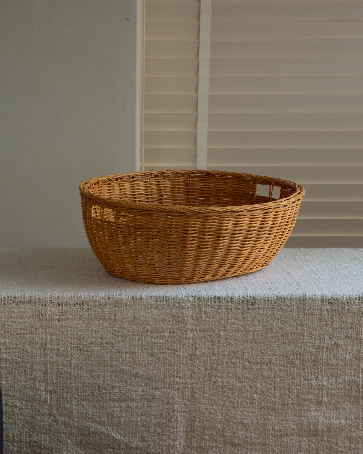 Natural rattan Dottie Basket, hand-woven with subtle handles for organic home storage.