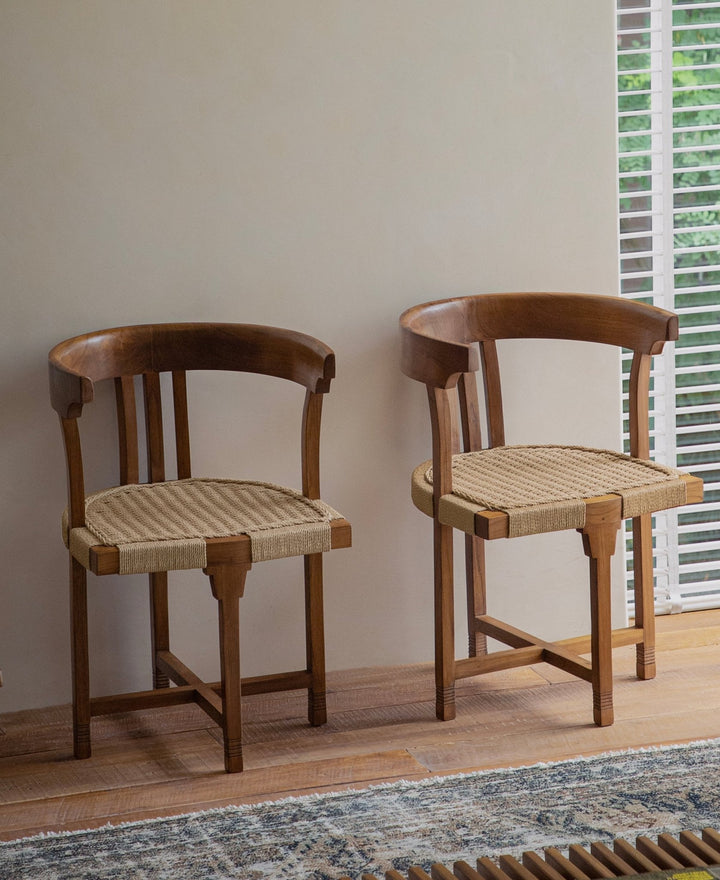 Teak dining chairs with woven seats in a cozy indoor setting