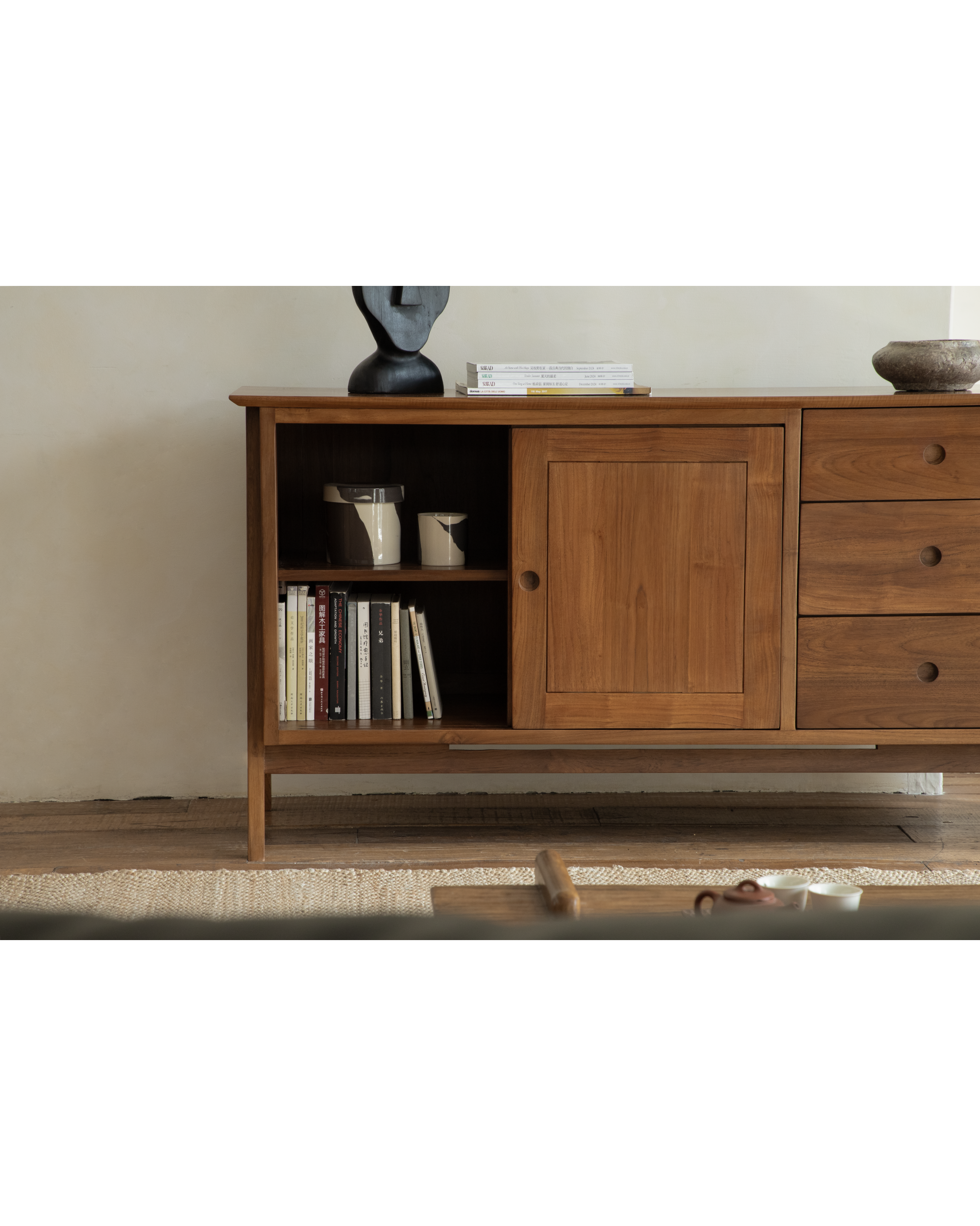 Teak sideboard with open shelves, sliding door, and three drawers, showcasing natural wood grain.