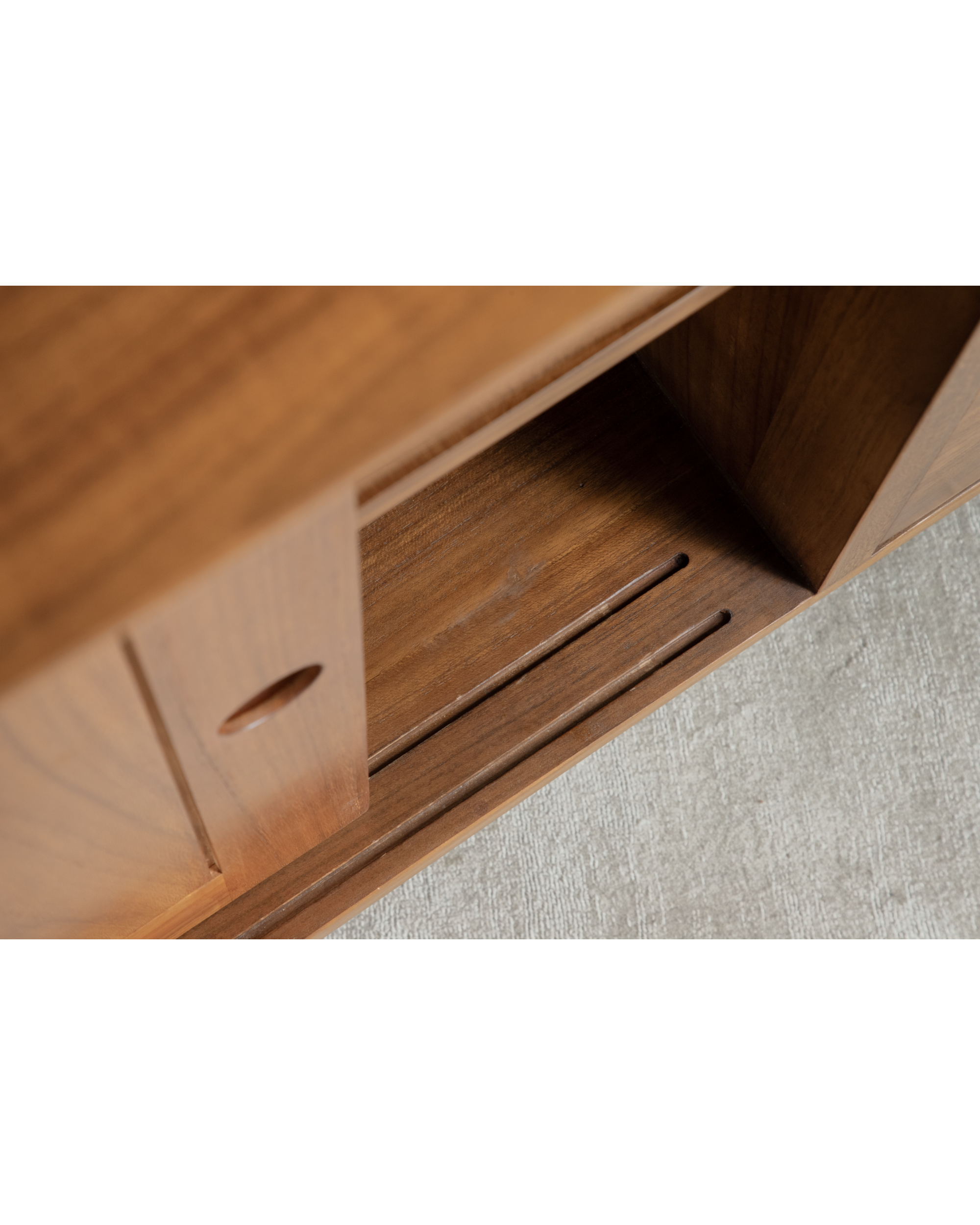 Close-up of warm teak wood grain on No.23 sideboard, revealing minimalist design.