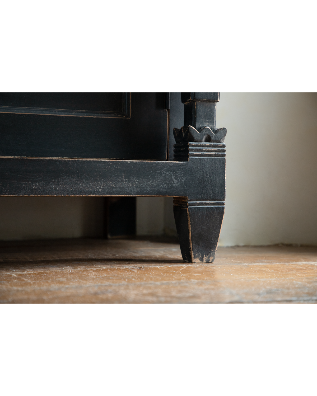 Vintage black teak cabinet leg with carved detailing and worn finish