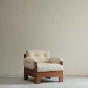 Raymond shearling armchair with a cream tufted sheepskin seat and back in a warm brown wood veneer frame with brass studs