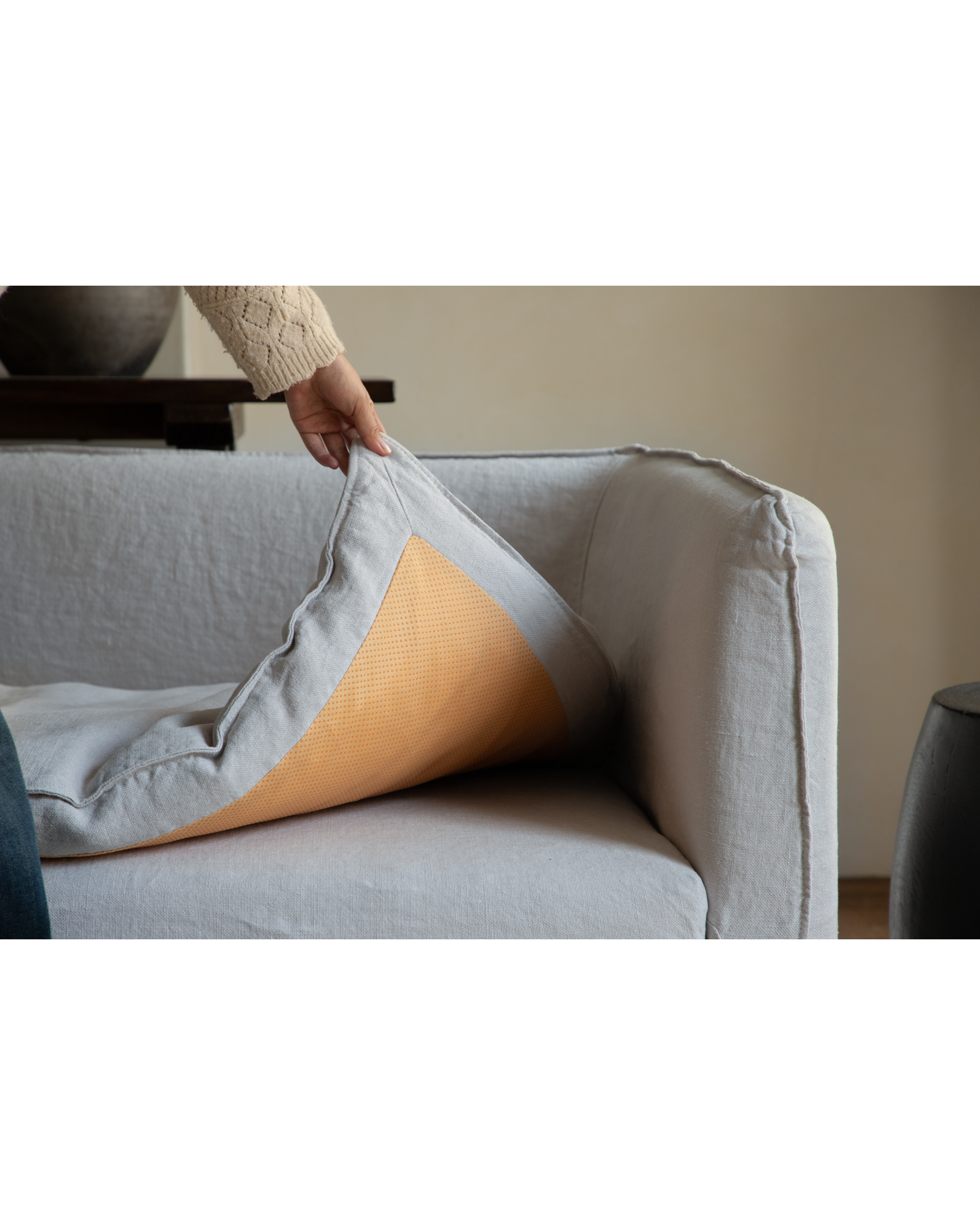 Camille Sectional Sofa: Close-up of grey linen cushion underside with orange non-slip backing.