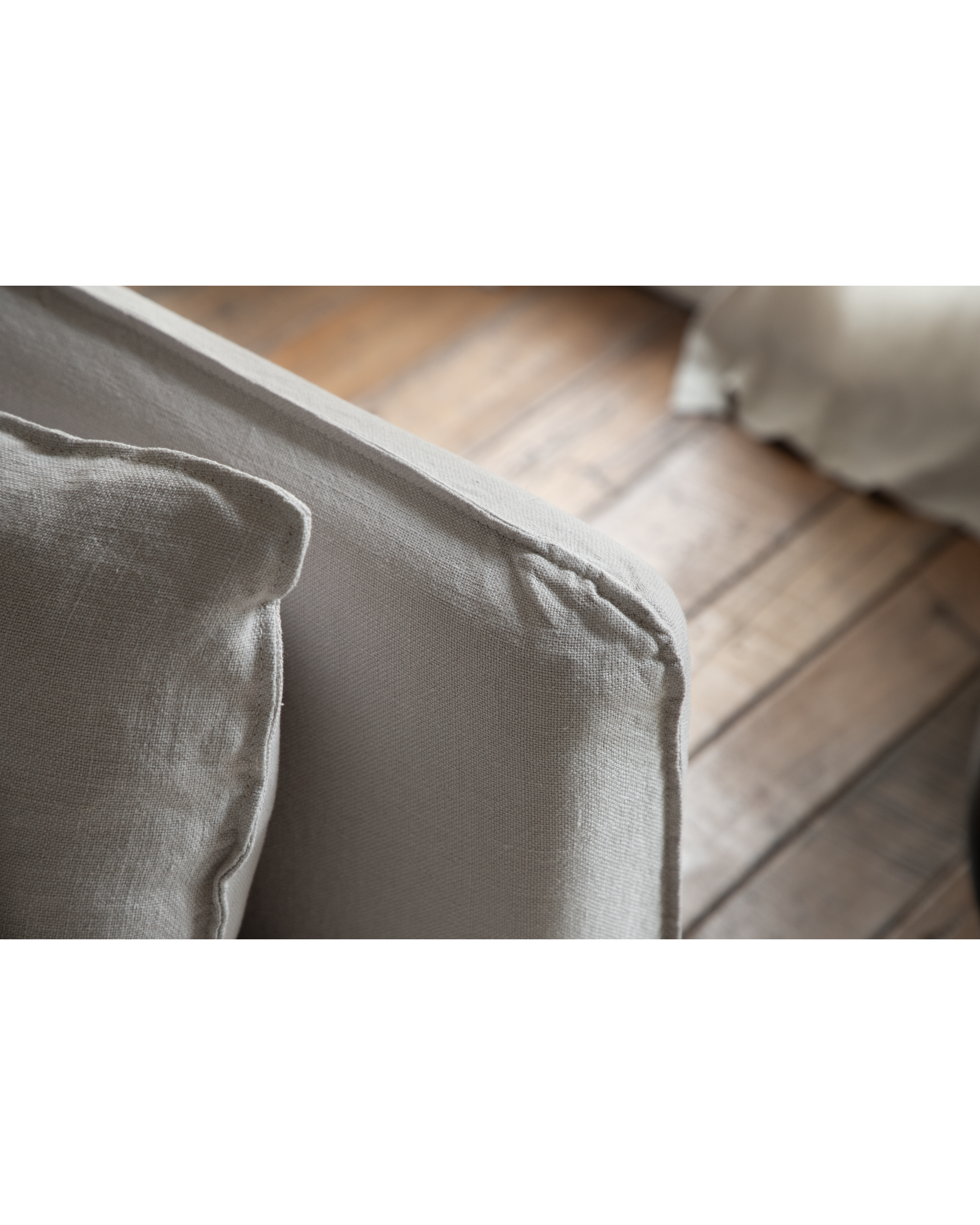 Close-up of Camille Sectional Sofa cushion in grey linen fabric, showing texture and seam detail.