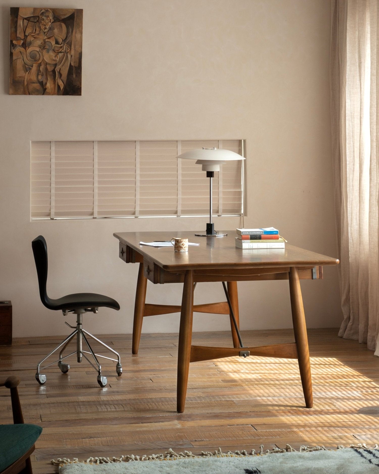 Architect Desk in a modern home office setting, teak wood desk with black office chair.
