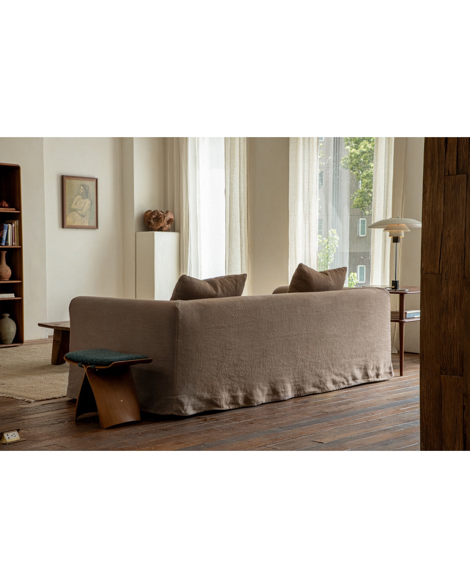 Charlotte Sofa in taupe linen, back view showing slipcover and cushions in a living room.