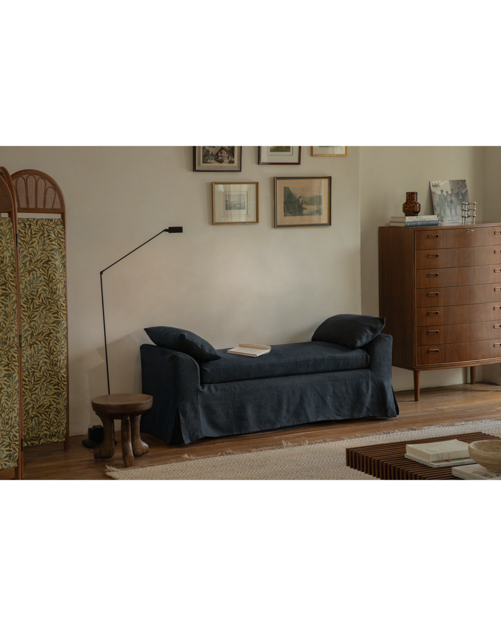 Alina Bench in dark charcoal linen upholstery with plush cushions and skirted base.