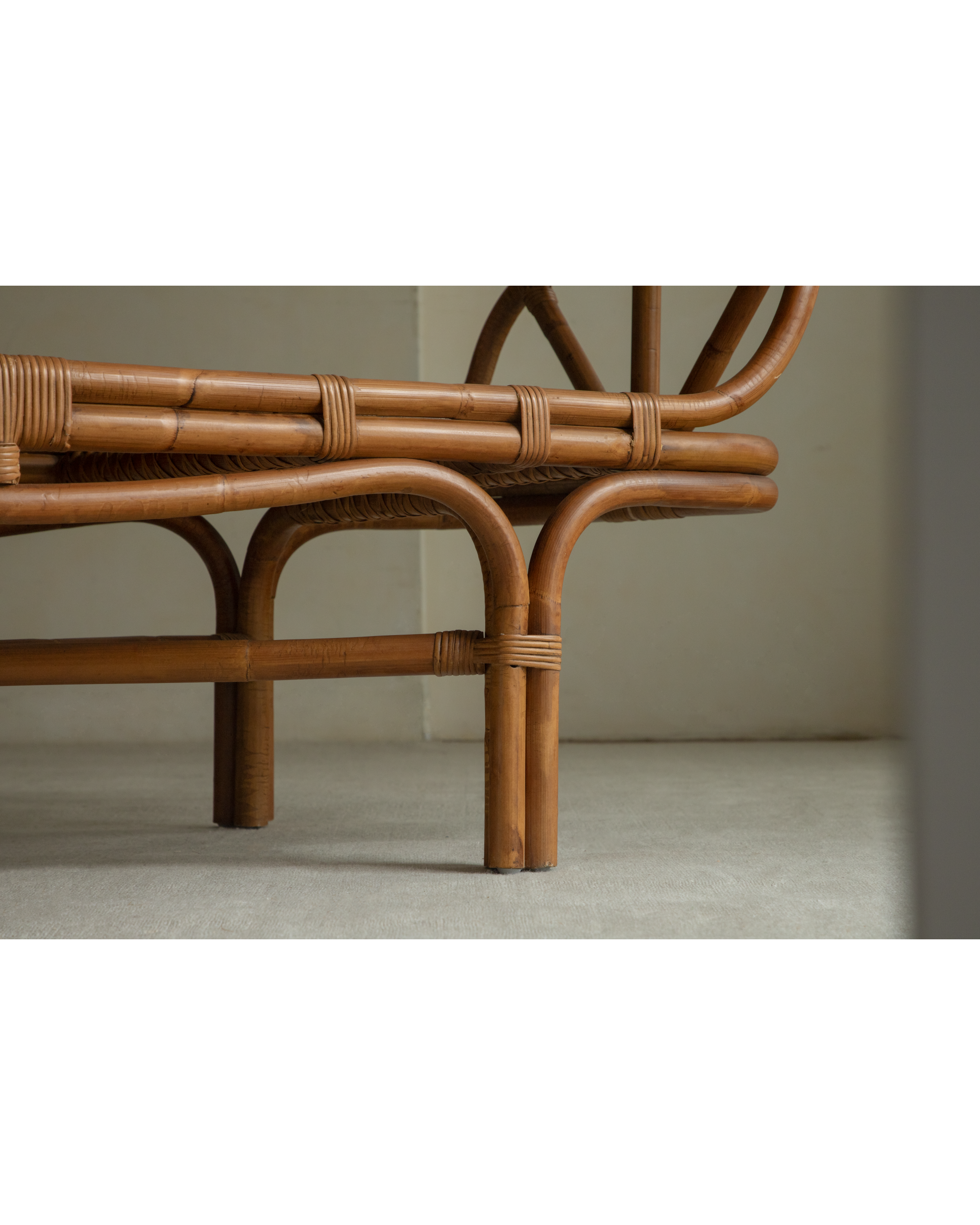 Bridget Bench: Rattan frame with woven detail and curved cane legs.