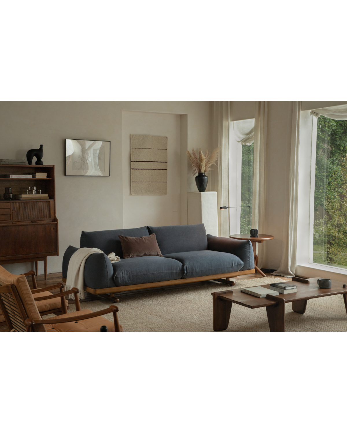 Adrian sofa in dark blue linen with teak base in a warm contemporary living room