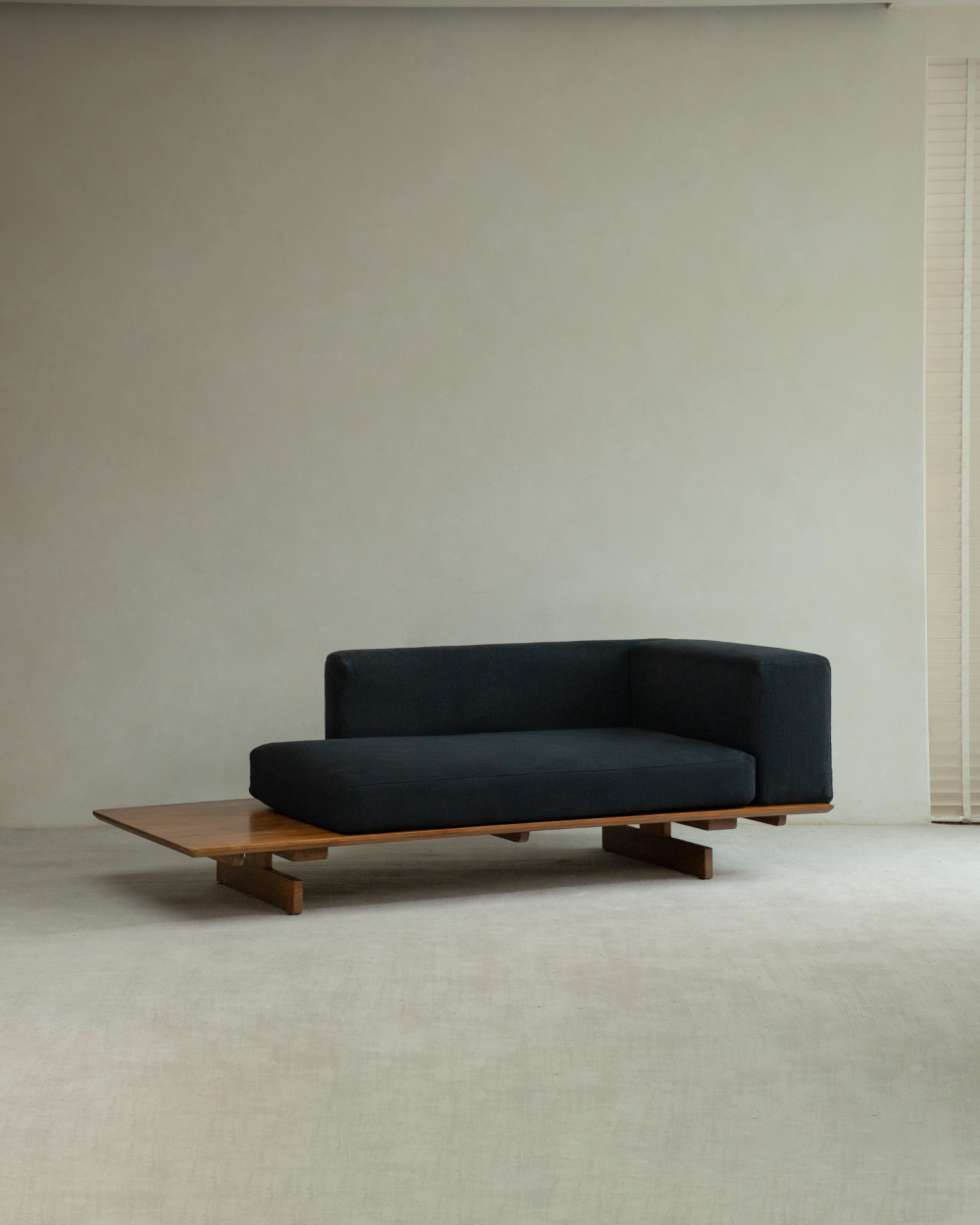 Black Tatami linen modular sofa with integrated teak wood side table and base.